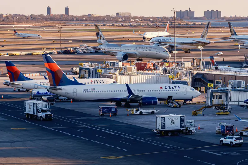Airliners parked at a busy terminal apron with service vehicles